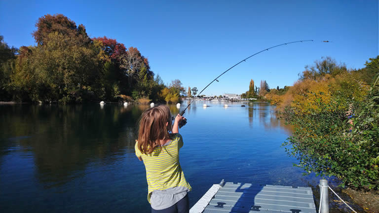 Kids fish for trout from Riverside Apartment Taupo